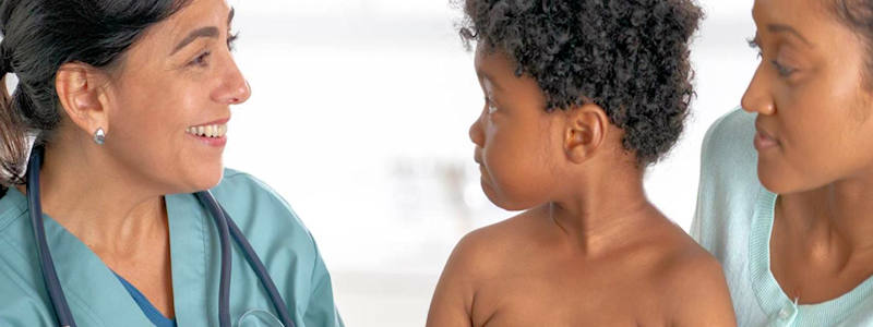 Doctor with child and parent/ guardian Doctor with child and parent/ guardian